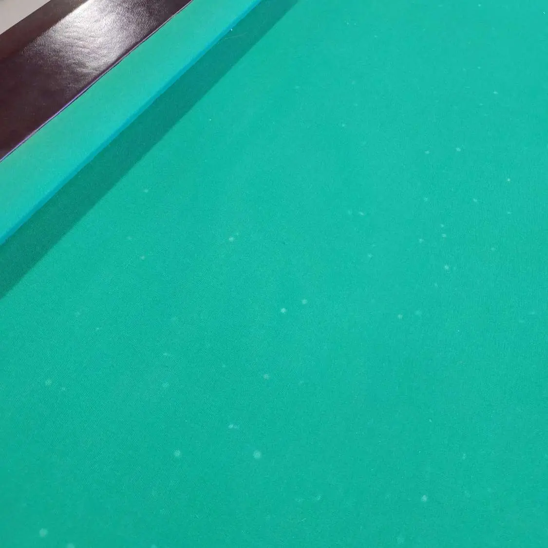 Pontos brancos no tecido da mesa de sinuca causados por queimadura de bola